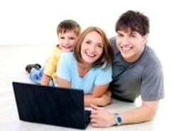 mom dad and son together smiling holding a laptop